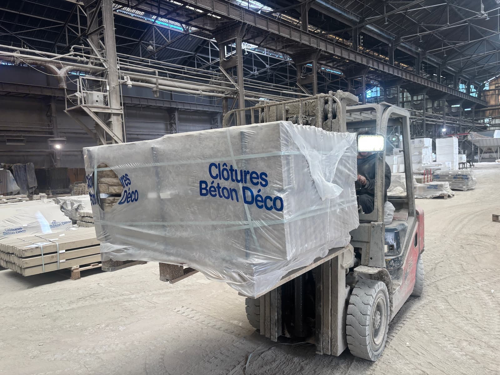 Manutention d'une palette de plaques béton dans l'atelier